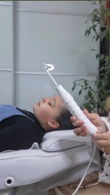 לקוחה במהלך טיפול פנים עם מנורת טיפול